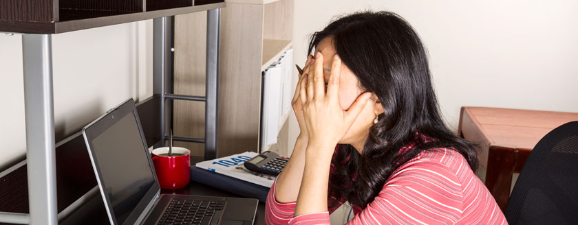 Stressed-out high school student with face in hands