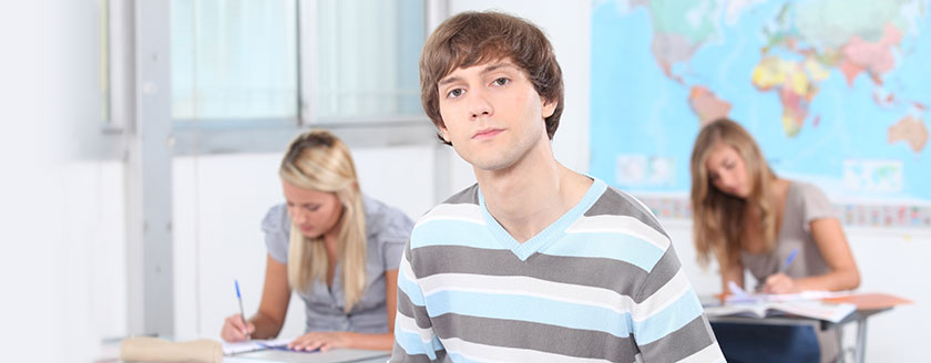 Three Students In Classroom With Map